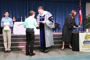 Dr. Ray presenting awards at the Honor Society ceremony. 